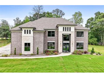 Stunning exterior of a brick home with a manicured lawn and a stone entryway, creating a welcoming curb appeal at 3012 Flat Shoals Rd, Conyers, GA 30094