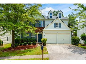 Charming two-story home featuring a well-manicured lawn, mature trees, and a two-car garage at 808 Plaintain Dr, Woodstock, GA 30188