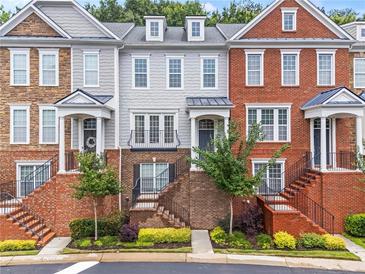 Townhome exteriors with brick and gray siding, featuring manicured landscaping and inviting entrances at 2343 Limehurst Ne Dr, Atlanta, GA 30319
