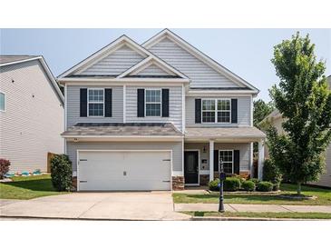Charming two-story home with a well-manicured lawn, two car garage, and classic architectural details at 319 Nobleman Way, Canton, GA 30114