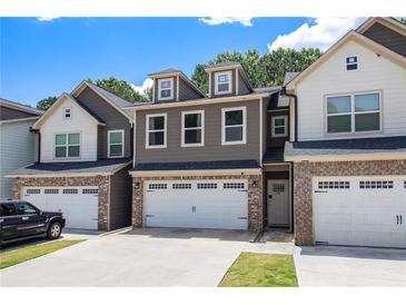 Charming townhome featuring a two-car garage and inviting curb appeal with neutral colors at 7805 Rock Rose Ln, Fairburn, GA 30213