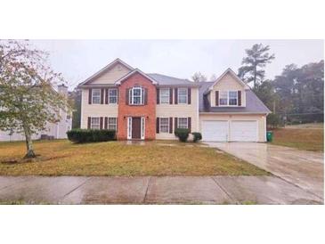 Traditional two-story home with a two-car garage, symmetrical design and landscaped front yard at 1857 Oak Hill Springs Blvd, Lithonia, GA 30058