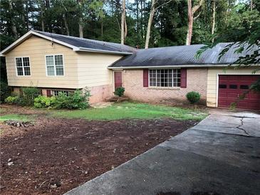 Charming single-story home with brick accents, complemented by a well-manicured lawn and mature trees at 3034 Kent Ct, Duluth, GA 30096