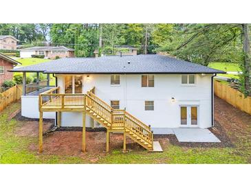 Expansive backyard view showcasing a new wooden deck and a painted brick house exterior at 2720 Cavalier Dr, Decatur, GA 30034