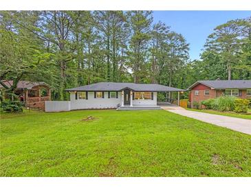 Charming remodeled single-story home featuring lush lawn and modern exterior at 2720 Cavalier Dr, Decatur, GA 30034