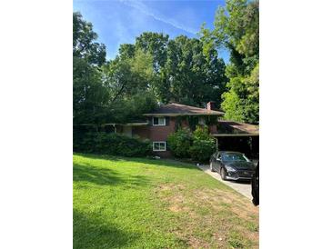 Charming brick two-story home with a well-maintained lawn and mature trees in a quiet neighborhood at 715 Catherine St, Forest Park, GA 30297