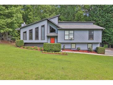 Charming home featuring a modern design, landscaped front yard, and a welcoming red front door at 3491 Birchwood Trl, Snellville, GA 30078