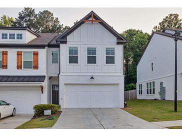 Charming two-story townhouse with white brick, a two-car garage, and contemporary design elements at 375 Auburn Valley Way, Auburn, GA 30011
