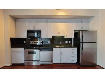 Well-lit kitchen features stainless appliances, dark countertops, and light-colored cabinets at 620 Glen Iris Ne Dr # 321, Atlanta, GA 30308