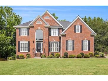 Charming two-story brick home with black shutters, a manicured lawn and mature landscaping at 1006 Kingsbridge Vw, Powder Springs, GA 30127
