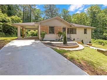 Charming home featuring a covered carport, stone accents, landscaped yard, and concrete driveway at 1641 Rockcliff Se Pl, Atlanta, GA 30316
