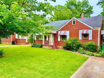 Charming brick home with green lawn and red and white striped awnings at 1968 Don Juan Ln, Decatur, GA 30032