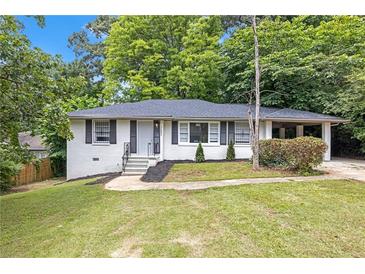 Charming ranch-style home featuring white brick, a cozy carport, and a lush front lawn at 2683 Rockcliff Se Rd, Atlanta, GA 30316