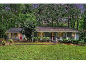 Charming single-story home with a welcoming front porch and a lush green lawn surrounded by mature trees at 5317 Highway 81, Loganville, GA 30052