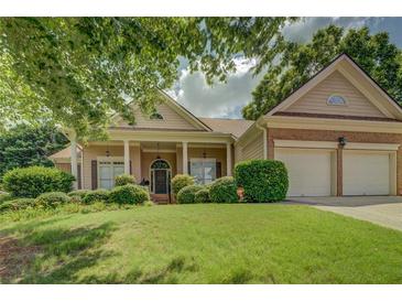 Charming home with a well-manicured lawn and a covered front porch with supporting columns, creating inviting curb appeal at 1065 Chippewa Oak Dr, Dacula, GA 30019