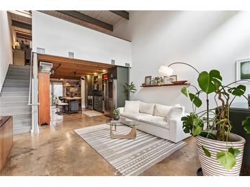 Inviting living room features an open floor plan, concrete floors, and a modern design at 1661 La France Ne St # 222, Atlanta, GA 30307