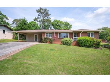 Charming single-story brick home with a covered carport and a well-maintained front yard with mature landscaping at 3332 Clay Rd, Austell, GA 30106