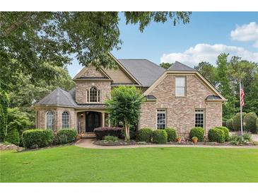 Charming brick home with manicured lawn, mature trees, and beautiful landscaping at 219 Deer Park Trl, Canton, GA 30114