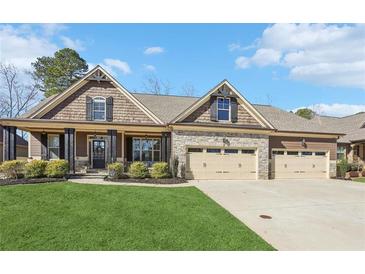 Charming home with a manicured lawn, inviting stone accents, and a spacious three-car garage at 266 Hanover Dr, Villa Rica, GA 30180