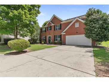 Charming two-story red brick home with a spacious driveway, attached garage, and well-manicured lawn at 750 Ambrose Ln, Atlanta, GA 30349