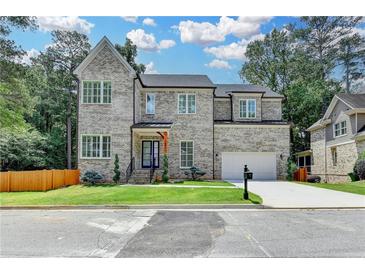 Beautiful two-story home with gray brick, manicured lawn and a two-car garage at 1169 Dorby Park Ne Dr, Brookhaven, GA 30319