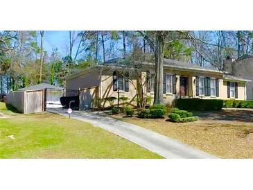 Charming brick home with well-manicured lawn, driveway, and lush landscaping at 3845 Pebble Beach Dr, Atlanta, GA 30349