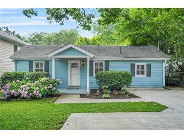 Charming blue house with a well-maintained lawn, garden and welcoming front porch at 877 Mclendon Dr, Scottdale, GA 30079