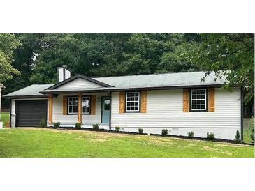 Charming single-story home featuring a garage, wooden shutters, and well-maintained landscaping at 2784 Oxford Dr, Decatur, GA 30034