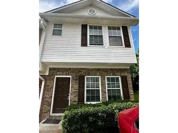 Traditional two-story townhome with white siding, brick accents, and a well-manicured front yard at 3609 Ginnis Rd, Atlanta, GA 30331