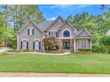 Charming two-story home with a manicured lawn and inviting stone accents at 407 Amber Ln, Woodstock, GA 30189