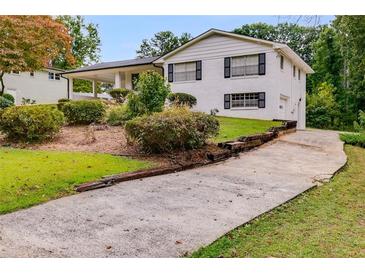 Charming two-story home featuring a white brick facade, dark shutters, and a well-manicured front lawn at 1083 Amelia Sw Dr, Marietta, GA 30060