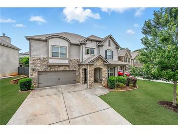 Charming two-story home featuring a stone facade, well-manicured lawn, and an attached two-car garage at 3291 Meadow Lily Ct, Buford, GA 30519