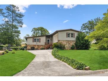 Charming two-story home featuring a stone facade, well-manicured lawn, and an inviting driveway at 3623 Doroco Dr, Atlanta, GA 30340