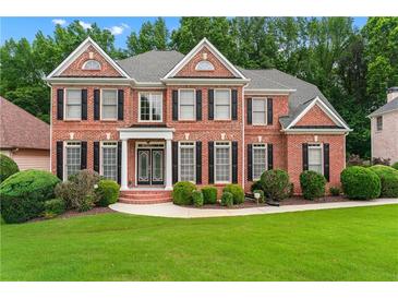 Elegant brick home with a manicured lawn and lush landscaping at 871 Windsor Creek Dr, Grayson, GA 30017
