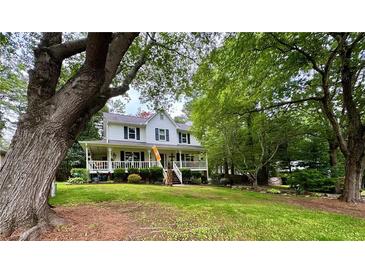 Charming two-story home with a large front porch and mature trees, situated on a well-manicured lawn at 4114 Falcon Shores Nw Ct, Acworth, GA 30101