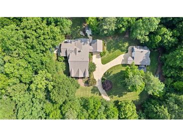 Aerial view of a private estate with a beautifully landscaped yard, mature trees, and multiple buildings at 654 Cannon Rd, Sharpsburg, GA 30277