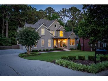 Charming home featuring a well-manicured lawn, inviting curb appeal, and mature trees at 1315 Woodland Trce, Cumming, GA 30041