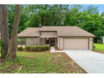 Charming single-Gathering home with a beige exterior and attached two-car garage, set amongst lush trees at 4818 Terrace Green Trce, Stone Mountain, GA 30088