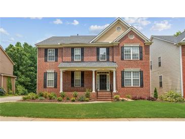 Charming two-story brick home with black shutters, a covered porch, and manicured lawn at 2667 Hampton Park Dr, Marietta, GA 30062