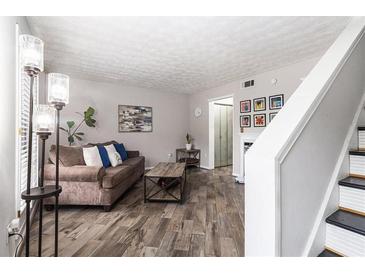 Comfortable living room featuring a cozy sofa, stylish decor, and wood-look laminate flooring at 3251 Abbeywood Dr, Decatur, GA 30034