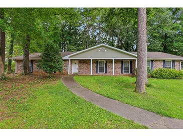 Charming brick home with well-manicured lawn and mature trees, creating a welcoming curb appeal at 763 Brookwood Sw Ter, Lilburn, GA 30047