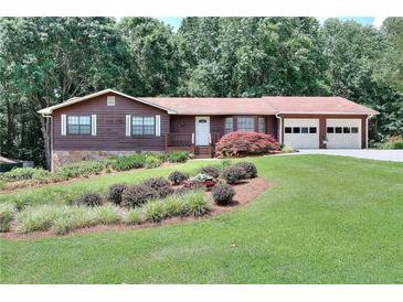 Charming single-story home boasts a well-manicured lawn, mature trees, and a two-car garage at 1123 Willow Trce, Grayson, GA 30017