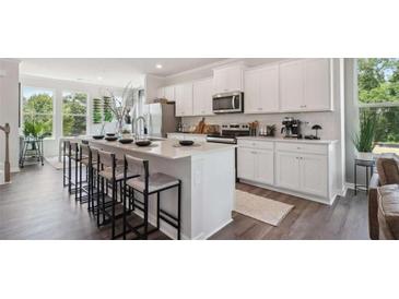Modern kitchen featuring white cabinetry, stainless steel appliances, and a large center island with seating at 218 College Cir # 1012, Hapeville, GA 30354