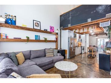 Bright living room with high ceilings, open shelving, and a comfortable sectional sofa at 1661 La France Stret Ne, Unit #216, Atlanta, GA 30307