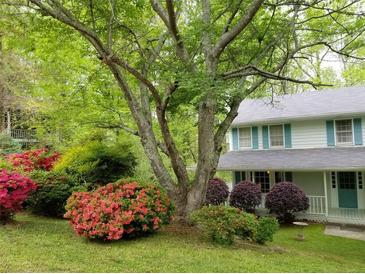Charming home featuring a lush front yard with colorful azaleas and a mature tree, offering curb appeal at 3875 Wintergreen Ct, Marietta, GA 30062