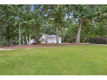 Charming single-story home with well-manicured lawn and mature trees at 408 Victoria Place Dr, Locust Grove, GA 30248