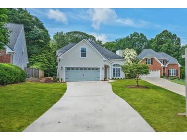 Beautiful traditional home with a well-manicured lawn and a long driveway leading to a two-car garage at 1950 Stethem Fry, Alpharetta, GA 30022
