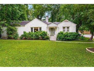 Charming white brick home with lush front yard and mature trees offers inviting curb appeal at 2119 Glenwood Se Ave, Atlanta, GA 30316