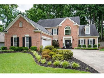 Charming brick home featuring manicured landscaping, black shutters, and a well-maintained lawn at 2192 Nine Oaks Nw Dr, Kennesaw, GA 30152
