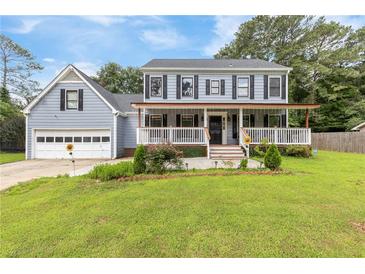 Charming two-story home with a covered front porch, attached garage, and well-maintained lawn at 1433 Janice Sw Ct, Lilburn, GA 30047